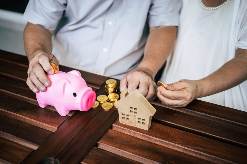 elderly couples talking about finance with piggy bank (1)